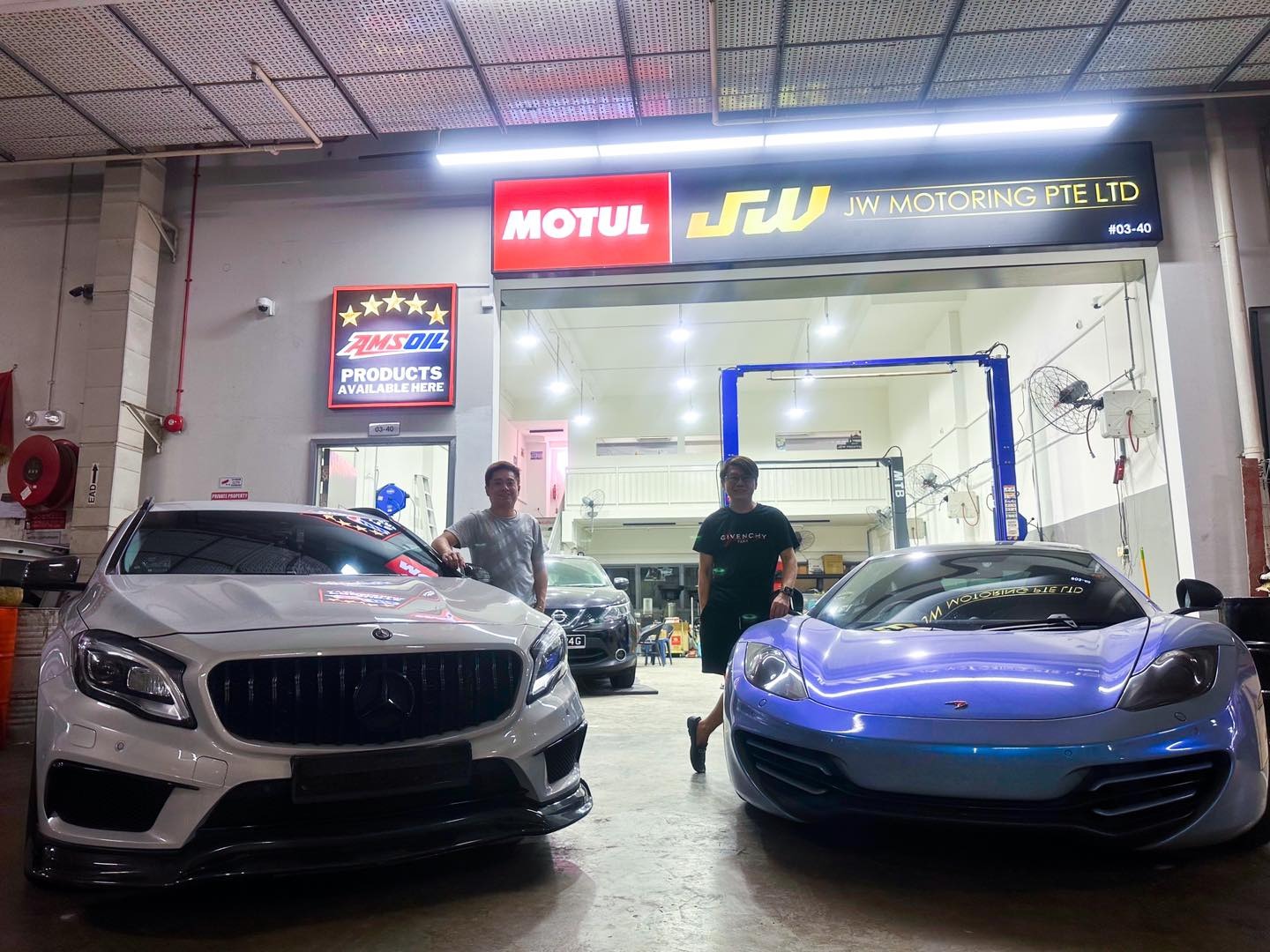 JW Motoring founders standing between a Mercedes-Benz and a McLaren outside the Kaki Bukit workshop