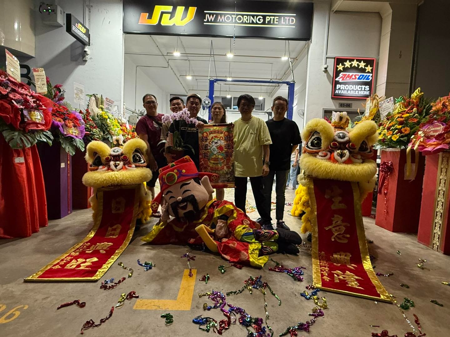 JW Motoring team at the workshop relaunch with traditional lion dance performers and celebratory decorations